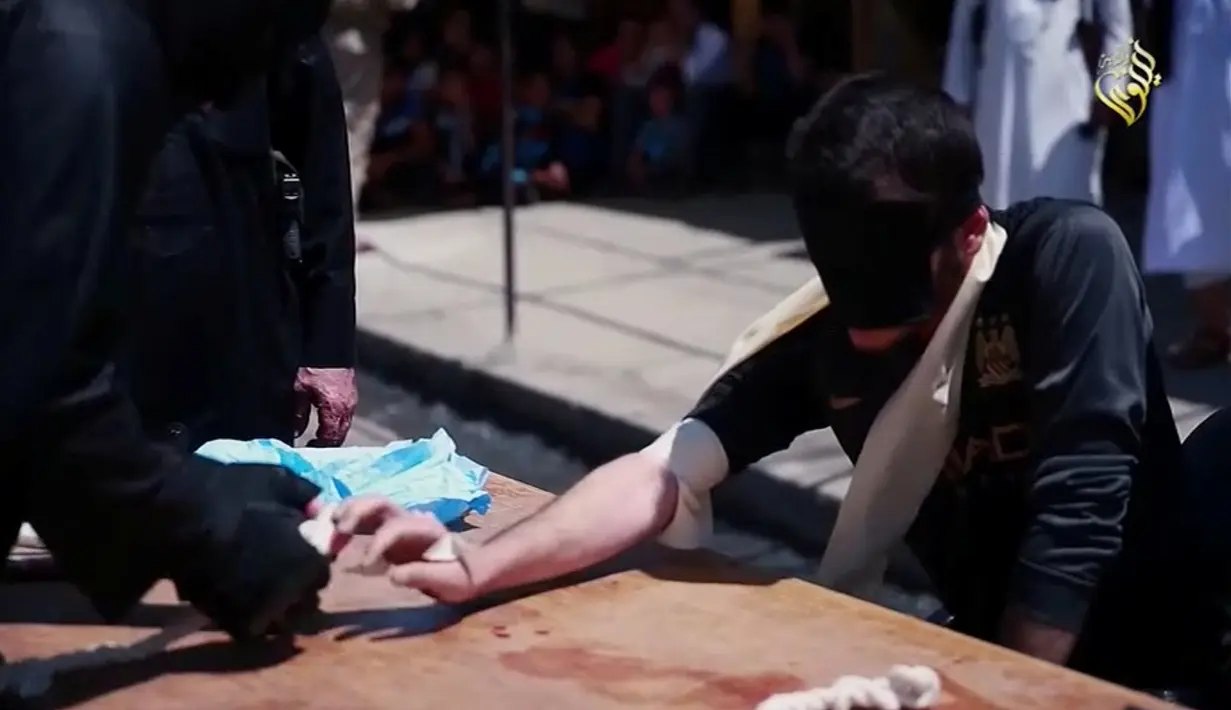 Suasana jelang eksekusi hukuman potong tangan terhadap pelaku kejahatan di Distrik Al-Karama, Mosul, Irak. Hukum syariah lainnya yang juga diterapkan ISIS yaitu hukuman cambuk. (Handout via Reuters)