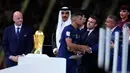 Pemain Prancis Kylian Mbappe berjabat tangan dengan Presiden Asosiasi Sepak Bola Argentina Claudio Tapia saat menerima penghargaan Sepatu Emas usai pertandingan sepak bola final Piala Dunia 2022 di Stadion Lusail, Lusail, Qatar, 18 Desember 2022. Kylian Mbappe berhak membawa pulang trofi penghargaan Sepatu Emas setelah menjadi pencetak gol terbanyak selama gelaran Piala Dunia 2022. (AP Photo/Natacha Pisarenko)