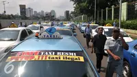 Armada sopir taksi saat melakukan demo di depan Gedung DPR/MPR, Jakarta, Selasa (22/3). Selain melakukan demo supir taxi tersebut melakukan sweeping ke sopir taksi yang beroperasi di dalam tol, dan membakar ban.(Liputan6.com/Johan Tallo)