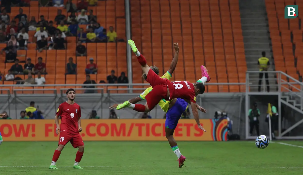 <p>Pemain Timnas Iran U-17, Mahan Sadeghi (depan) berduel udara dengan pemain Timnas Brasil U-17, Pedro Lima pada laga pertama Grup C Piala Dunia U-17 2023 di Jakarta International Stadium (JIS), Jakarta, Sabtu (11/11/2023). (Bola.com/Ikhwan Yanuar)</p>