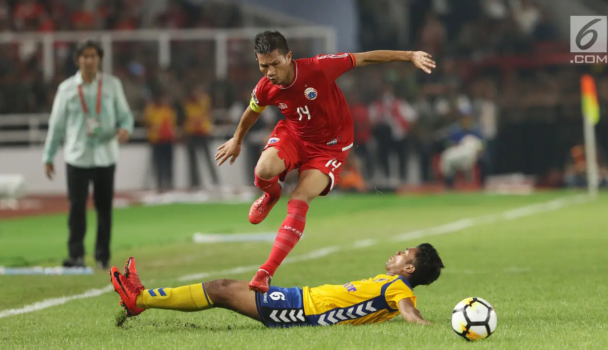 Bek Persija, Ismed Sofyan melompat menghindari tekel pemain Tampines Rovers pada penyisihan grup H Piala AFC 2018 di Stadion GBK, Jakarta, Rabu (28/2). Persija unggul 4-1. (Liputan6.com/Helmi Fithriansyah)