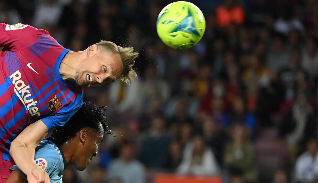 <p>Pemain depan Barcelona, Luuk de Jong (kiri) berebut bola dengan bek Celta Vigo Joseph Aidoo pada laga lanjutan La Liga di Camp Nou, Rabu (11/5/2022) dini hari WIB. Barcelona menghajar Celta Vigo 3-1 di kandang sendiri. (LLUIS GENE / AFP)</p>