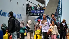 Para penumpang berjalan keluar untuk turun dari kapal di pelabuhan Perak, Surabaya, Jawa Timur pada Minggu 15 Maret 2026. Arus mudik di Pelabuhan Tanjung Perak, Surabaya, Jawa Timur, memasuki periode dengan jumlah penumpang yang signifikan. (JUNI KRISWANTO/AFP)