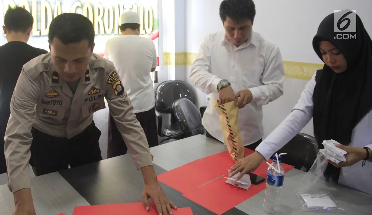 Petugas kepolisian merapikan barang bukti narkoba usai konferensi pers di Polda Gorontalo, Senin (13/5/2019). Direktorat Reserse Narkoba Polda Gorontalo menetapkan lelaki berinisial WR sebagai tersangka narkoba setelah diringkus saat jelang bulan Ramadhan lalu. (Liputan6.com/Arfandi ibrahim)