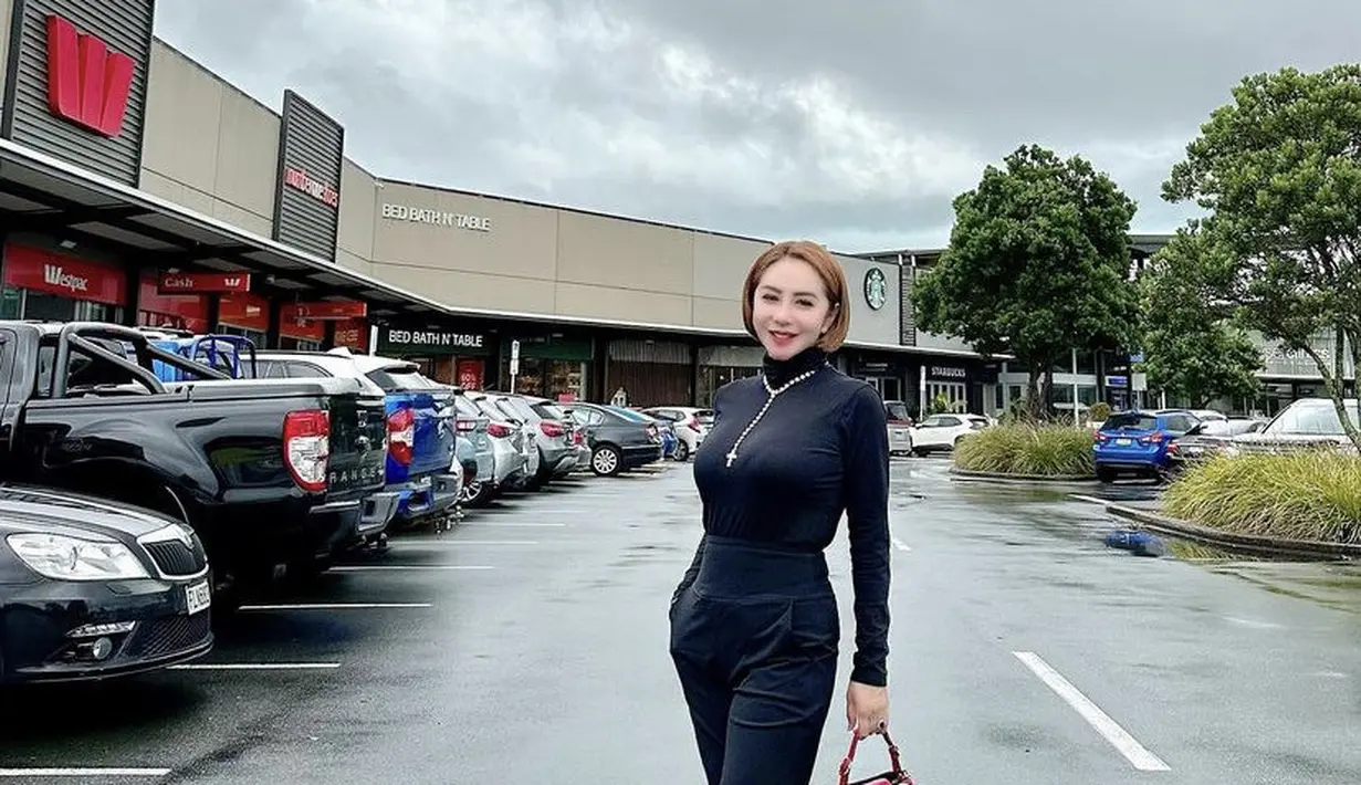 Ia juga tampil serba hitam dari atasan turtle neck dan celananya. Ia memadukannya dengan knee boots cokelat dan tas Valentino merah. (@femmypermatasari)