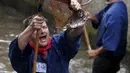 Seorang Nelayan bergembira usai mendapatkan ikan saat hari nelayan di Memmingen, Jerman, Sabtu (25/7/2015). Peserta yang menangkap ikan terbesar akan diberi nama "Raja Nelayan" selama satu tahun. (REUTERS/Michaela Rehle)