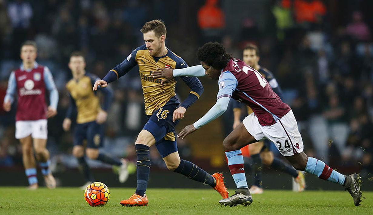 Gelandang Arsenal, Aaron Ramsey, berusaha melewati pemain Aston Villa, Carlos Sanchez, pada laga Liga Premier Inggris di Stadion Villa Park, Inggris, Minggu (13/12/2015). (Reuters/Paul Childs)