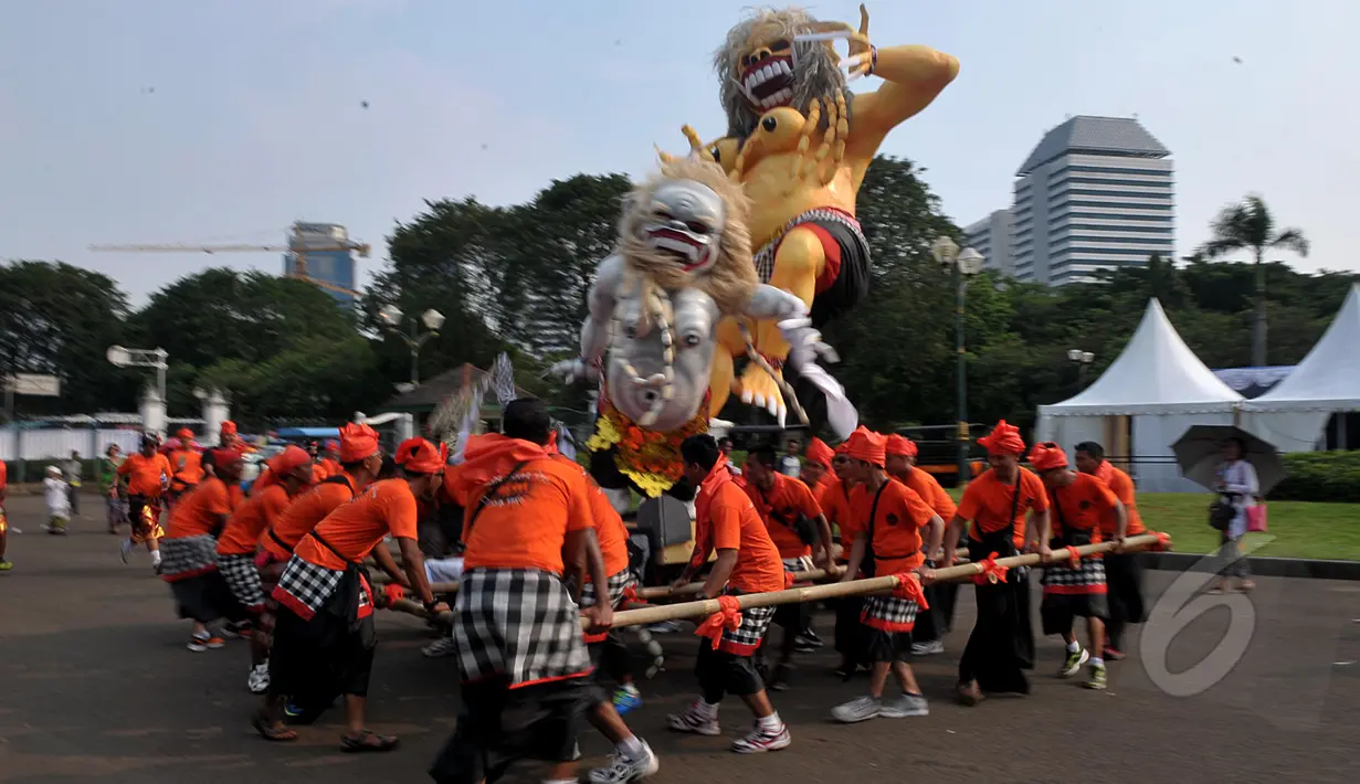 Sejumlah pemuda mengarak boneka raksasa dalam pawai Ogoh-ogoh di kawasan Monas, Jakarta, Jumat (20/3/2015). Pawai tersebut merupakan rangkaian dari prosesi menjelang Hari Raya Nyepi Tahun Saka 1937. (Liputan6.com/Johan Tallo)