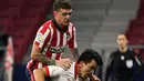 Bek Atletico Madrid, Kieran Trippier (kiri) melompati bek Sevilla, Marcos Acuna saat berebut bola dalam lanjutan Liga Spanyol 2020/2021  di Stadion Wanda Metropolitano, Madrid, Spanyol, Rabu (13/1/2021) dini hari WIB. Atletico Madrid membungkam Sevilla dengan skor 2-0. (PIERRE-PHILIPPE MARCOU/AFP)