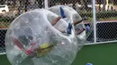 Beberapa pemain terlihat terjatuh saat bermain sepakbola di dalam sebuah gelembung berbentuk bola di Beijing, Kamis (10/7/14). (REUTERS/Kim Kyung-Hoon)