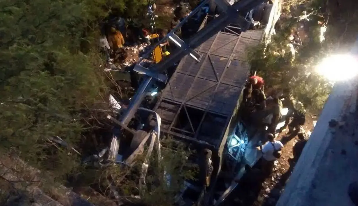 Petugas menggunakan alat berat mengevakuasi bus yang jatuh dari sebuah jembatan di utara Provinsi Salta, Argentina, Senin (14/12). Sedikitnya 42 polisi tewas dan lainnya terluka ketika bus yang ditumpangi menabrak jembatan dan terjun ke jurang (AFP Photo)