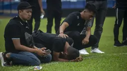 Suasana mengharukan menyelimuti saat mereka berada ditengah lapangan. Mereka tidak dapat menyembunyikan rasa sedih hingga tangisan kembali pecah. (AFP/Juni Kriswanto)