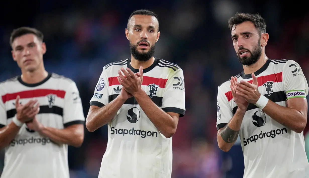 Pemain Manchester United, Manuel Ugarte, Noussair Mazraoui, dan Bruno Fernandes (kiri ke kanan) bertepuk tangan kepada para penggemar di akhir Liga Premier Inggris melawan Crystal Palace di Selhurst Park, London, Sabtu, 21 September 2023. (AP Photo/Kin Cheung)