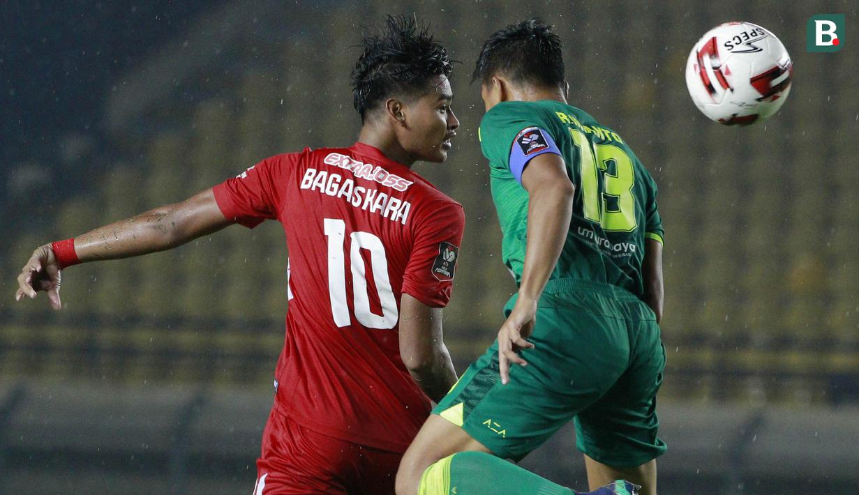 Bek Persebaya Surabaya, Rachmat Irianto (kanan) berduel udara dengan striker Persik Kediri, Septian Bagaskara dalam laga Grup C Piala Menpora 2021 di Stadion Si Jalak Harupat, Bandung, Selasa (23/3/2021). Persebaya menang 2-1 atas Persik. (Bola.com/M Iqbal Ichsan)