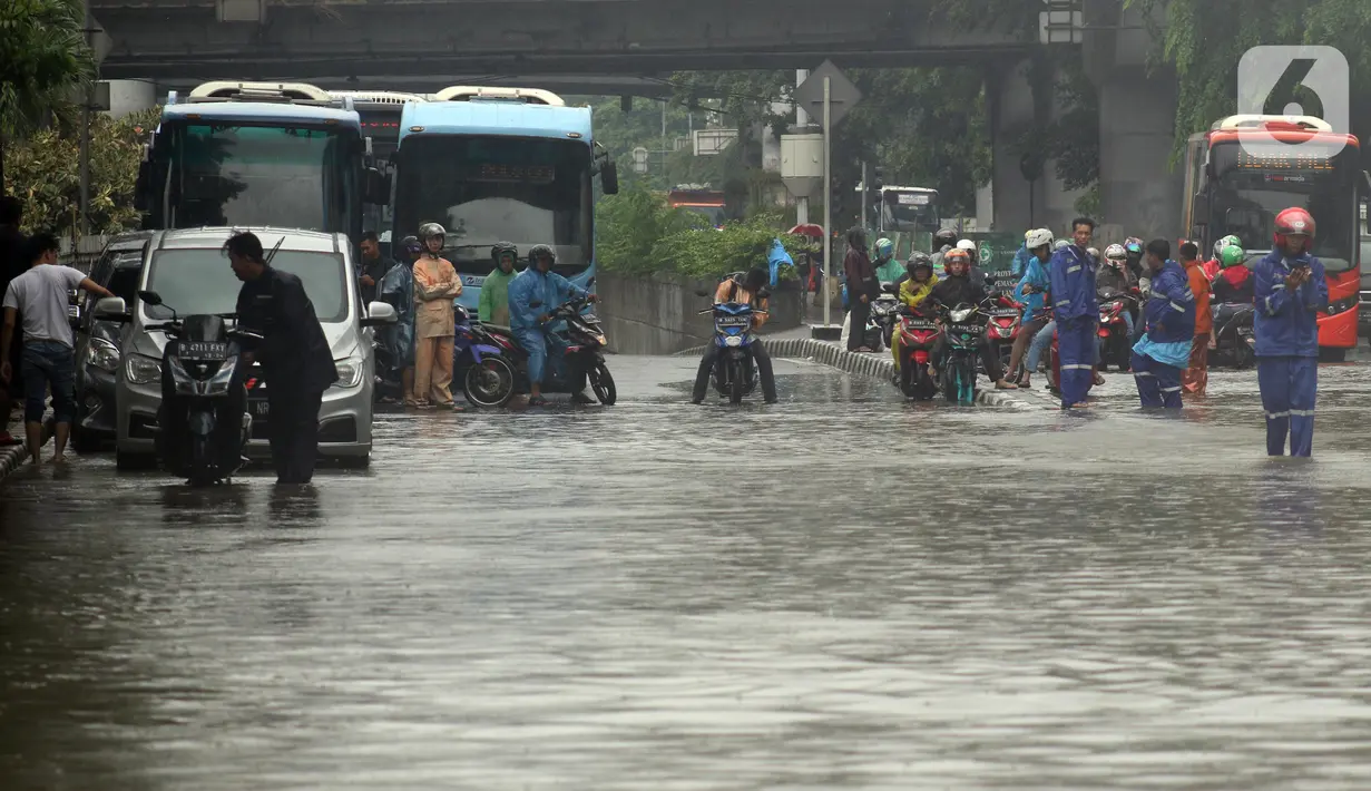 Pengendara antre melintasi Jalan Di Panjaitan dekat Halte Transjakarta Cawang Soetoyo yang banjir, Jakarta, Rabu (1/1/2020). Hujan yang mengguyur Jakarta sejak Selasa sore (31/12/2019) mengakibatkan banjir di sejumlah titik di Jakarta. (Liputan6.com/Helmi Fithriansyah)