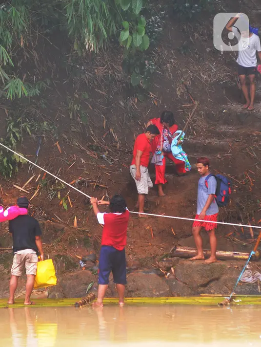 Warga bersiap menaiki rakit untuk menyeberangi Sungai Cikaniki di Rumpin, Bogor, Rabu (15/1/2020). Akibat banjir bandang merobohkan jembatan yang menghubungkan Desa Tonjong Rumpin dan Desa Kantalarang Leuwiliang, warga terpaksa memanfaatkan perahu rakit untuk melintas. (merdeka.com/Arie Basuki)