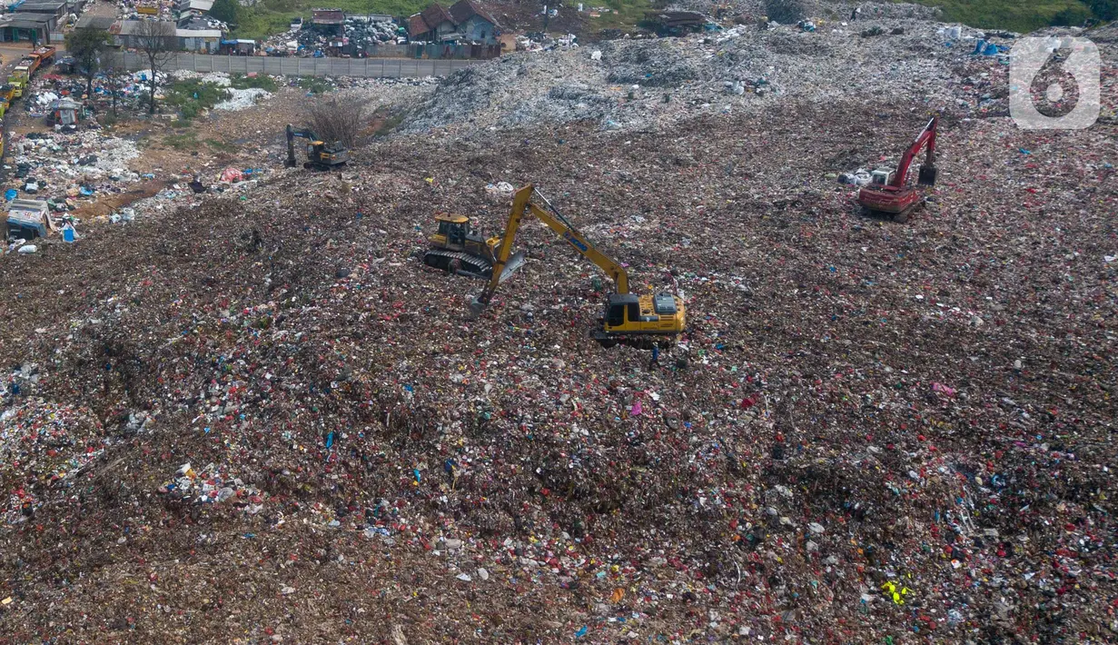 Alat berat eskavator  meratakan gunungan sampah di tempat Pembuangan Sampah Akhir (TPA) Burangkeng, Bekasi, Jawa Barat, Senin (6/5/2024). TPA Burangkeng rencananya akan memperluas lahan pembuangan sampah. (merdeka.com/Imam Buhori)