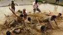 Sejumlah warga Nepal bermain di lumpur pada Asar Pandra, atau hari menanam padi di Lalitpur, 29 Juni 2018. Asar Pandra diadakan sebagai tanda dimulainya kembali aktivitas tanam padi di sawah saat musim hujan tiba. (AP Photo/Niranjan Shrestha)