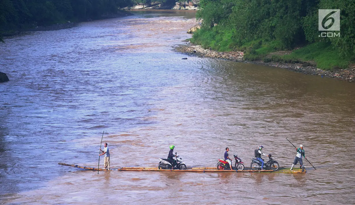 Sebuah rakit mengangkut motor dan warga menyeberangi Sungai Cisadane di Rumpin, Bogor, Selasa (13/3). Mereka terpaksa menaiki rakit akibat jembatan Gerendong yang merupakan akses jalan utama Ciseeng -Rumpin masih dalam perbaikan. (Merdeka.com/Arie Basuki)