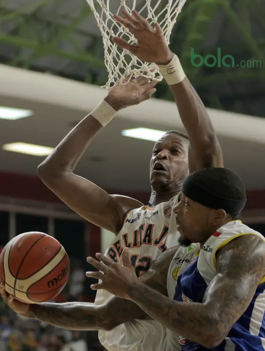 Aksi pemain Satria Muda, Jamarr Johnson melakukan lay up saat diadang pemain Pelita Jaya, Chester Giles pada Final IBL 2018 di GOR Sumantri Brojonegoro, Jakarta, Minggu (22/4/2018). Satria Muda menang 69-64. (Bola.com/Nick Hanoatubun)