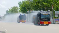 Mobil Polda Riau melakukan penyemprotan cairan disinfektan untuk mengurangi penularan Covid-19. (Liputan6.com/M Syukur)