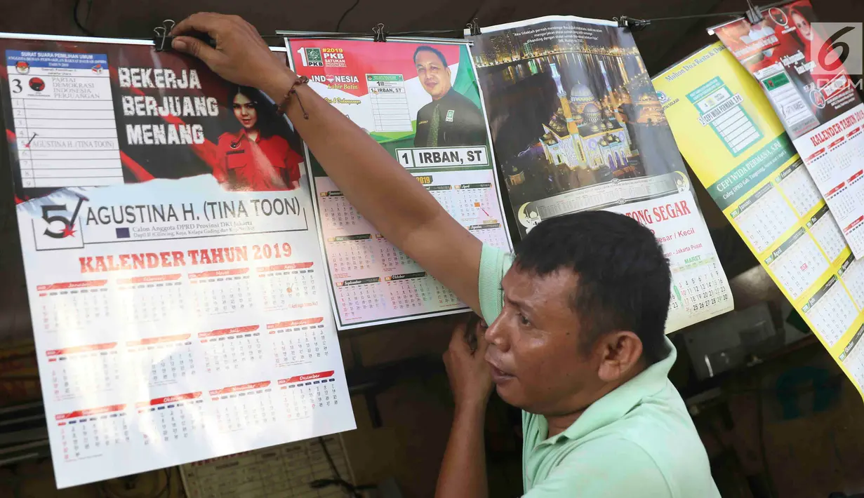 Pekerja menunjukkan kalender tahun 2019 di kawasan Senen, Jakarta, Jumat (7/12). Menjelang berakhirnya tahun 2018, produksi kalender di kawasan pusat percetakan tersebut meningkat 40 persen. (Liputan6.com/Immanuel Antonius)