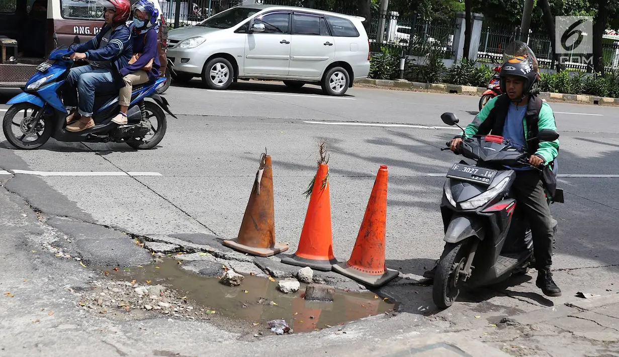 Pengendara menghindari jalan berlubang di kawasan Tanjung Barat, Jakarta, Rabu (30/1). Musim penghujan, pengguna jalan mengeluhkan jalan berlubang yang dipenuhi air.  (Liputan6.com/Immanuel Antonius)