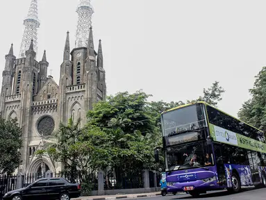Bus tingkat wisata jurusan Pasar Baru-Bundaran HI melintas di Kawasan Gereja Katedral, Jakarta, (6/10/14). (Liputan6.com/ Faizal Fanani)