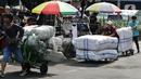 Sejumlah porter mengangkut barang di kawasan Pasar Tanah Abang, Jakarta, Senin (27/3/2023). (Liputan6.com/Johan Tallo)