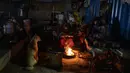 Sebuah keluarga tunawisma dan anjing mereka duduk di sekitar api unggun di luar tempat penampungan tunawisma pada malam yang dingin di New Delhi, Rabu, 28 Desember 2022. Angka resmi menunjukkan 195 tempat penampungan tunawisma di kota itu hanya dapat menampung sekitar 19.000 orang, menyisakan puluhan dari ribuan berjuang untuk tetap hangat. (AP Photo/Altaf Qadri)