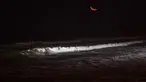 Seorang wisatawan meluncur ke dalam gulungan ombak saat berselancar di pantai La Pampilla, ibu kota Peru, Lima, 2 Maret 2017. Sekelompok peselancar hardcore memilih bermain selancar pada malam hari. (AP Photo/Rodrigo Abd)