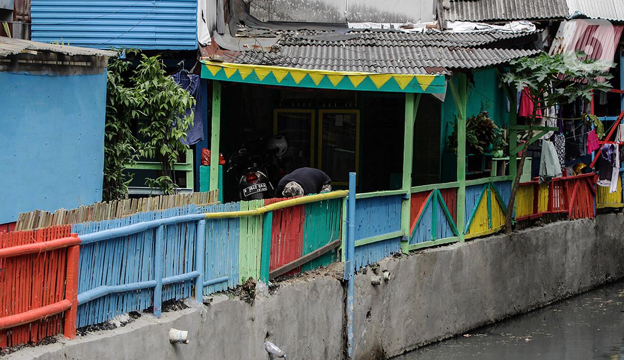 Aktivitas warga di kampung Unggulan yang dihiasi mural di Tanah abang, Jakarta, Selasa (6/12/2022). Pembuatan mural sepanjang 100 meter di kampung unggulan tersebut sudah dilakukan awal november 2022 dan program dari Pemerintah Provinsi DKI Jakarta. (Liputan6.com/Johan Tallo)