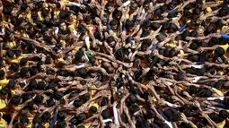 Ribuan umat Hindu membentuk piramida manusia untuk mencapai dan memecahkan dahi-handi (pot yang terbuat dari tanah liat) pada Festival Janmashtami di Mumbai, India, 6 September 2015. Festival ini menandai kelahiran dewa Krishna (REUTERS/Danish Siddiqui)