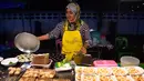 <p>Penjual membuat makanan untuk pembeli  selama bulan suci Ramadhan di pasar malam di provinsi Narathiwat, Thailand selatan (21/4/2022). Penjual makanan jalanan mendirikan kios mereka untuk menjual makanan kepada umat Muslim untuk berbuka puasa. (AFP/Madaree Tohlala)</p>