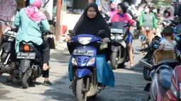 Pengendara motor tidak mengenakan masker masuk ke Pasar Bukit di Tangerang Selatan, Banten, Rabu (22/7/2020). Warga masih tidak peduli kesehatan dirinya sendiri dan orang lain, tentang bahayanya penyeberan virus corona (COVID-19) yang terus meningkat di Indonesia. (merdeka.com/Dwi Narwoko)
