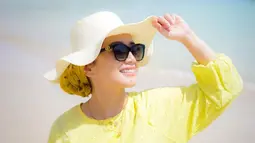 Dine Mutiara tampil memesona dengan topi dan kacamata di pantai. Baju kuningnya juga kian memperlihatkan sisi cerah dari istri Sahrul Gunawan. Potret cantiknya ini banjir pujian dari warganet. (Liputan6.com/IG/dine.pearl)
