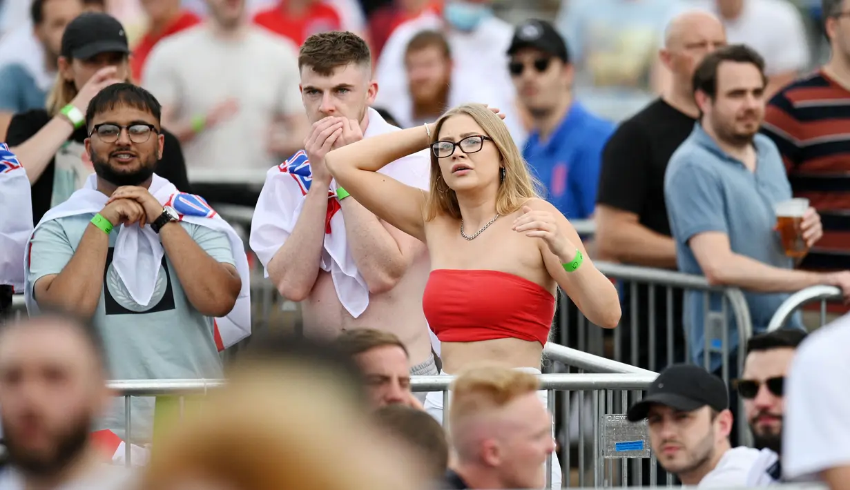Suporter wanita ini tampak begitu tegang melihat aksi pasukan Tiga Singa melawan Tim Panser di babak 16 besar Euro 2020. (AFP/Oli Scarff)