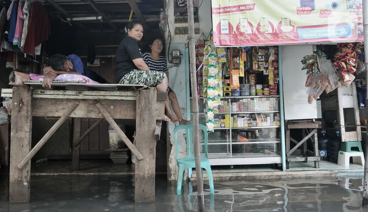Aktivitas warga di tengah banjir yang masih merendam Kampung Rawa Indah, Jakarta Utara, Senin (24/2/2020). Kampung yang terletak di dua kelurahan, yakni Sukapura dan Pegangsaan Dua tersebut masih terendam banjir hingga sore ini dengan ketinggian air 30-50 cm. (merdeka.com/Iqbal S Nugroho)