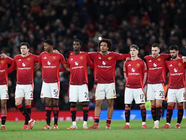 Para pemain Manchester United berjejer selama adu penalti dalam pertandingan putaran kelima atau 16 besar Piala FA 2024-2025 melawan Fulham di stadion Old Trafford, Inggris, pada Minggu (2/3/2025) malam WIB. (Darren Staples/AFP)