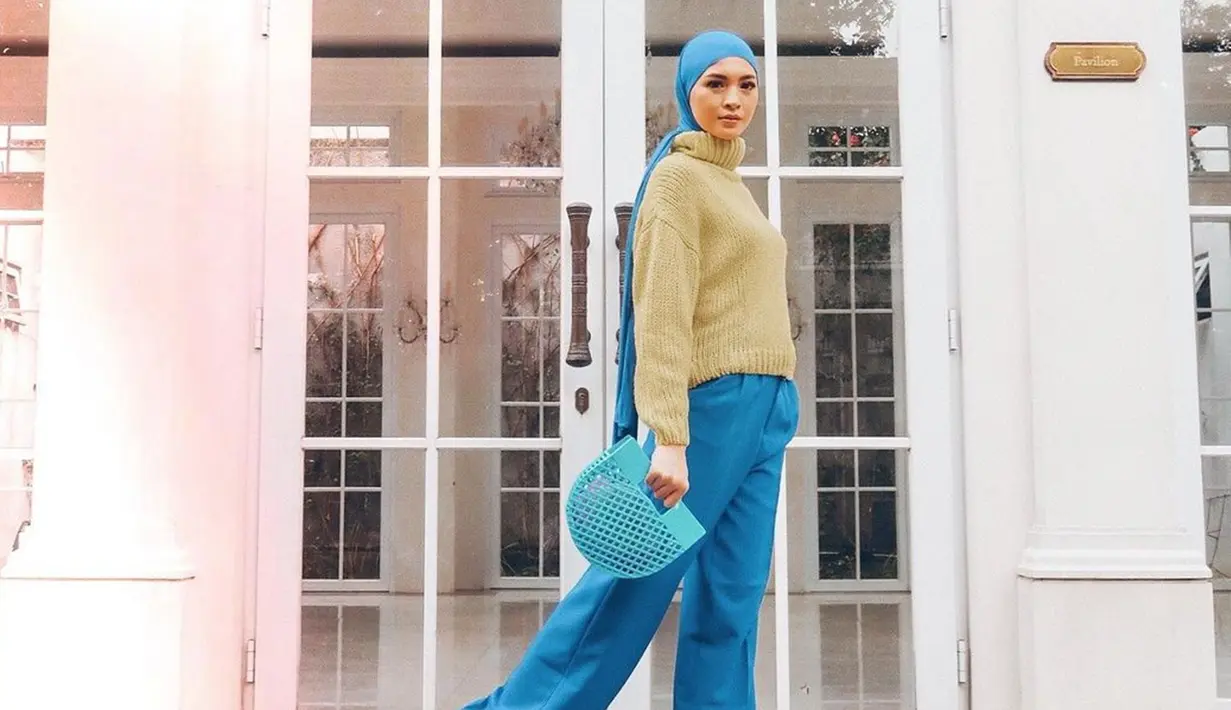 Dirinya juga pernah memadukan turtle neck berwarna krem cokelat dengan hijab serta celana berwarna biru. Penampilan Donita ini pun membuatnya terlihat lebih cerah. (Liputan6.com/IG/@donitabhubiy)