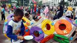 Anak-anak bermain di Lapangan Banteng, Jakarta, Minggu (14/10). Lapangan Banteng yang dahulu sepi sekarang menjadi tempat favorit warga untuk mengajak anaknya bermain. (Liputan6.com/JohanTallo)