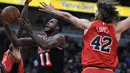 Pemain Miami Heat, Dion Waiters (tengah) melakukan tembakan saat diadang pemain Chicago Bulls, Robin Lopez (42) dan Justin Holiday (7) pada laga NBA basketball game di United Center, Chicago, (26/11/2017). Miami Heat menang 100-93.  (AP/Paul Beaty)