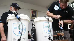 Field Director Waves for Water, Rob Mcqueen dan BMW Clubs International Council George Nyktas, menjelaskan cara kerja filter Care4Water di RPTRA Krendang, Tambora, Jakarta Barat, Minggu (28/4/2019). Care4Water dilengkapi dengan membran 0,1 micron yang menyaring kotoran. (Liputan6.com/Ismail)
