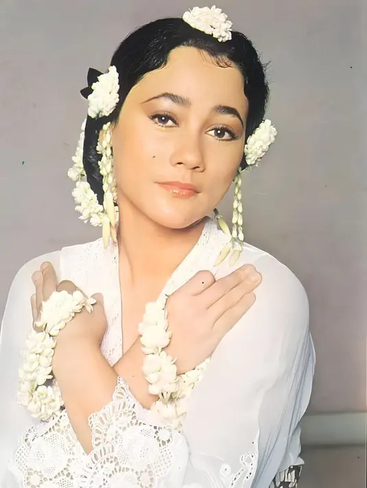 <p>Suzzanna&nbsp; dikenal memiliki ciri khas mengenakan melati, seperti foto ini memadukan kebaya putih dengan aksesori melati di lengan dan sanggul rambutnya.&nbsp;[@suzzannaofficial]</p>