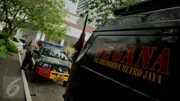 Seorang anggota polisi bersandar di samping mobil Tim Gegana yang dikerahkan ke Balai Kota DKI Jakarta, Rabu (20/7). Pengamanan kantor Gubernur Ahok diperketat setelah menerima ancaman teror bom dari orang tak dikenal. (Liputan6.com/Gempur M Surya)