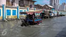 Kendaraan melintas di jalan yang tergenang air di Muara Angke, Jakarta, Senin (2/1). Rencananya Pemprov DKI akan membuat tanggul penahan air rob di kawasan tersebut. (Liputan6.com/Faizal Fanani)