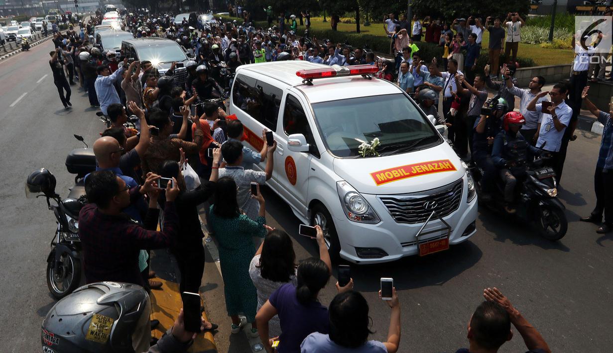 Iring-iringan mobil jenazah yang membawa almarhum Presiden ke-3 RI, BJ Habibie melintasi Jalan Gatot Subroto menuju TMP Kalibata, Jakarta, Kamis (12/9/2019). Warga secara khusus meluangkan waktu menyambut jenazah BJ Habibie untuk memberikan penghormatan terakhir. (Liputan6.com/Johan Tallo)