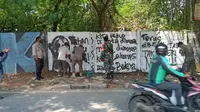 Anggota Satpol PP melakukan penghapusan mural bertuliskan kritikan di Jalan Raya Citayam, Kelurahan Depok, Kecamatan Pancoran Mas, Kota Depok. (Istimewa)
