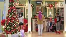 Pengunjung berfoto bersama keluarga dengan dekorasi Natal di atrium Lippo Mall Puri, Jakarta Barat, Sabtu (19/12/2020). Dominasi warna merah dan pohon cemara berhias lampu meriahkan sambut Hari Raya Natal dan Tahun Baru di atrium 1 dan 2. (Liputan6.com/Fery Pradolo)