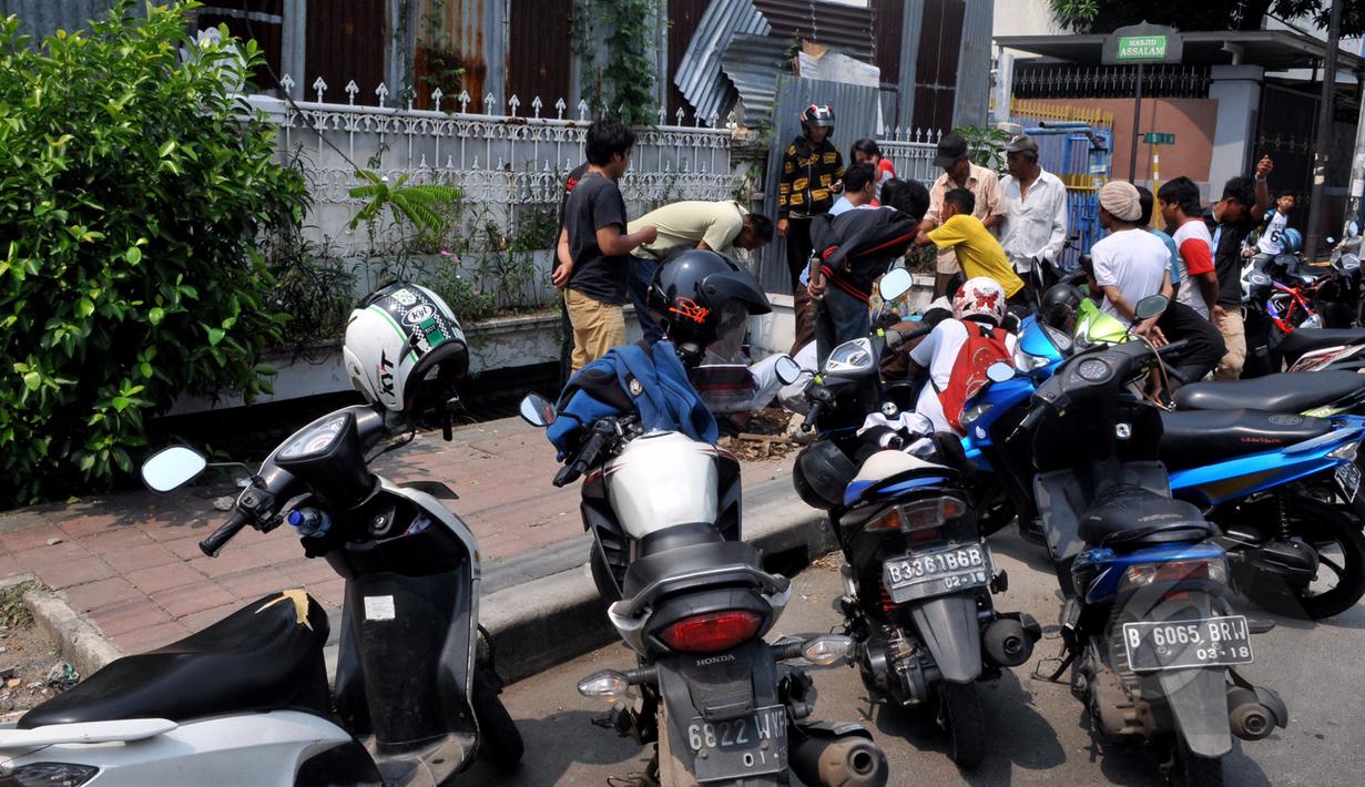 Warga berkerumun untuk mencari batu jenis giok di trotoar  Kawasan Tomang, Jakarta, Sabtu, (9/5/2015). (Liputan6.com/Andrian M Tunay)